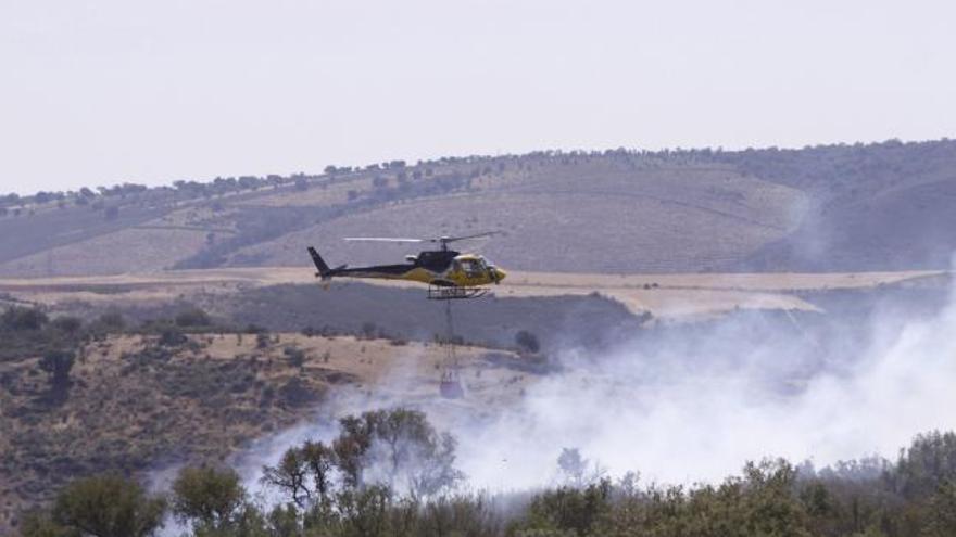 Un helicóptero con la carga de agua para esparcirla en el incendio de Videmala.