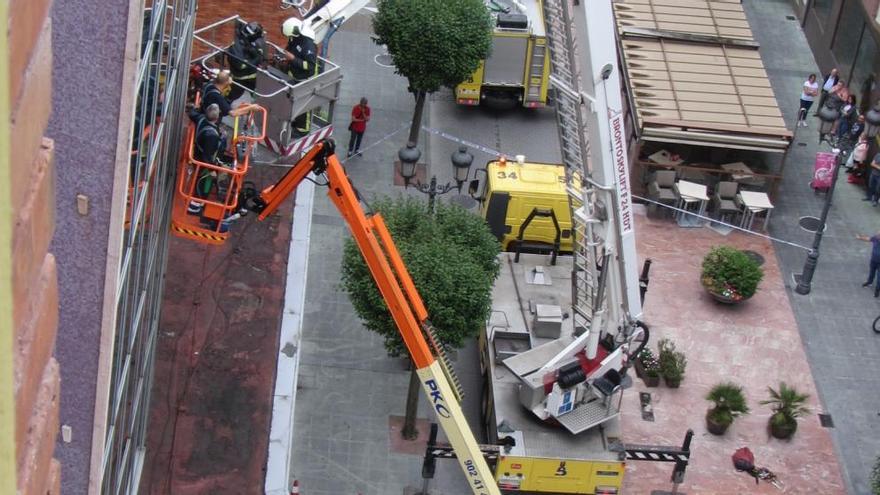 Los bomberos rescatan en Sama a dos operarios cuya cesta se averió a varios metros de altura