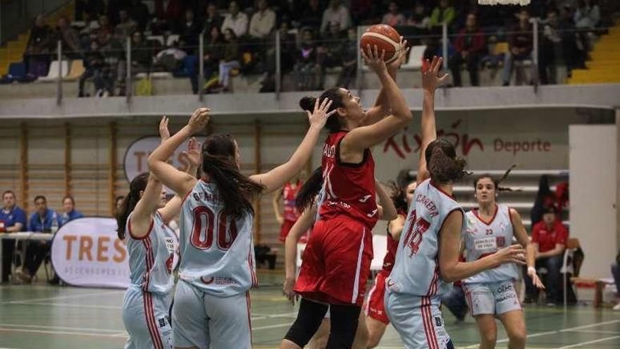 Calvelo lanza a canasta rodeada de jugadoras rivales.