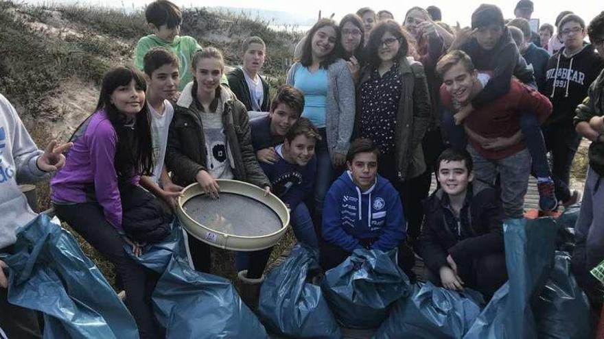 Alumnos de primero de ESO del Instituto As Bizocas participantes en la jornada de limpieza simultánea de playas, en Area da Cruz. // Muñiz