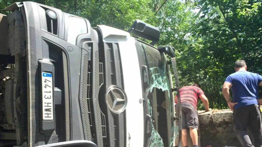 El camión, ayer, volcado en la carretera.