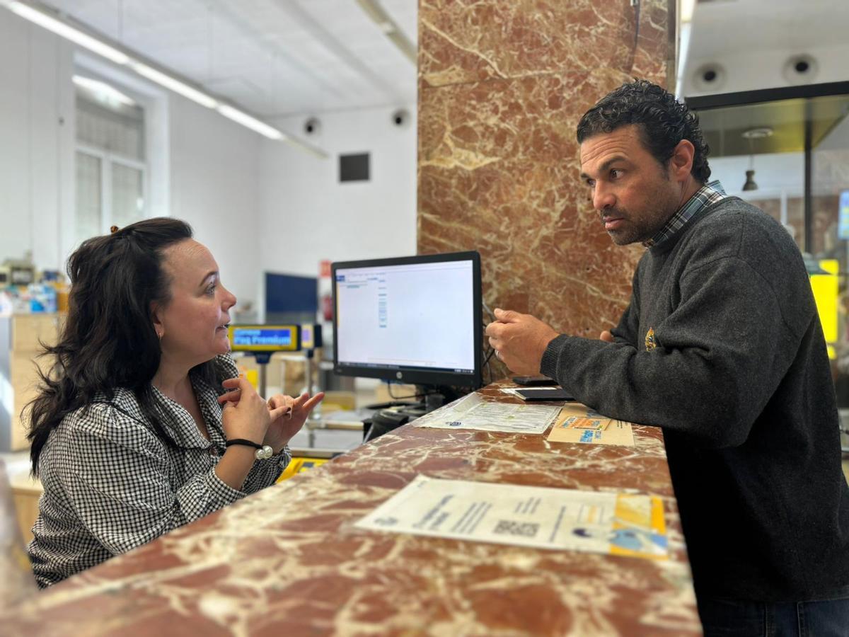 Alexander Bécquer, migrante, recibe información en la oficina de Correos de Badajoz.