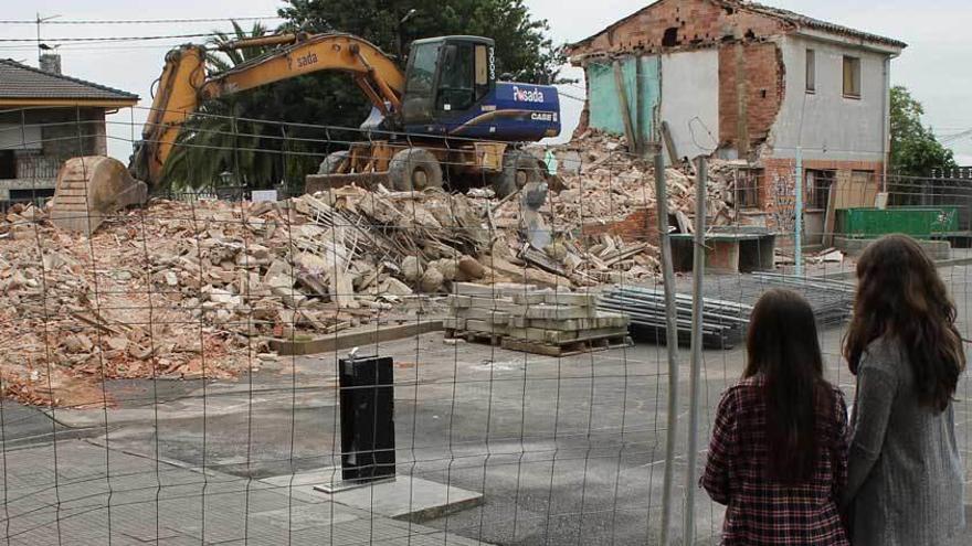 Unas niñas observan las casas derruidas.