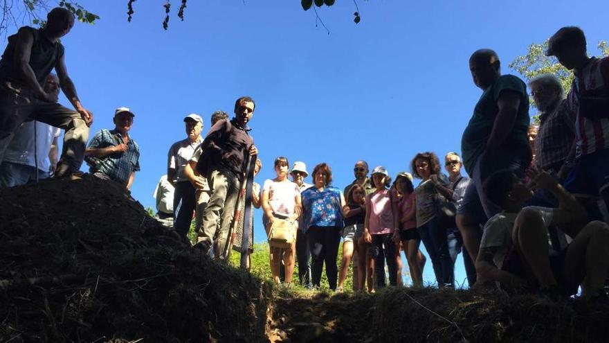 El arqueólogo Juan Ramón Muñiz (en el centro) explica a los vecinos las últimas investigaciones realizadas en el castro de Antrialgo.