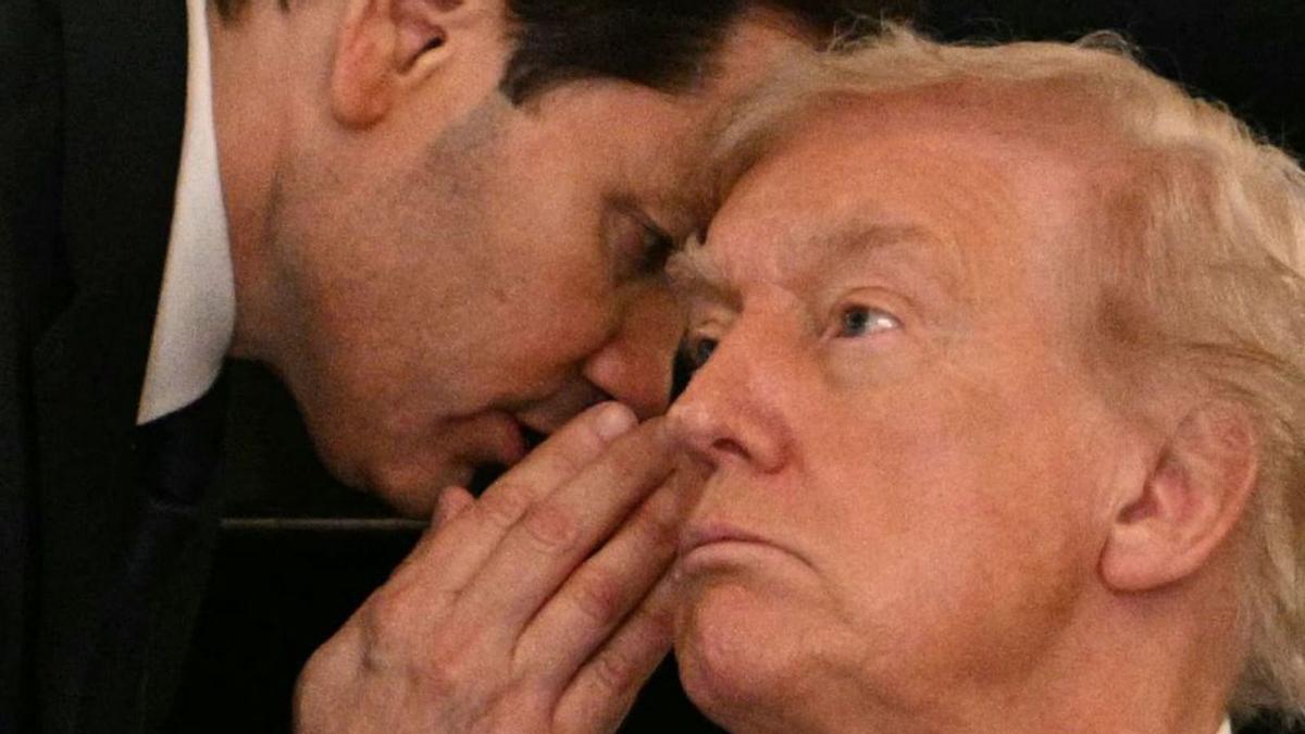 Marco Rubio xiuxiueja a l’orella de Donald Trump. | JIM WATSON / AFP