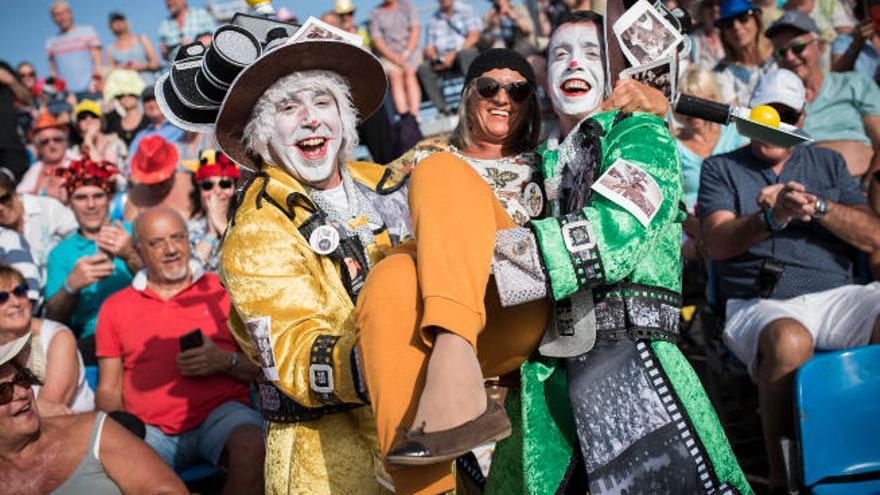 Dos mascaritas levantan en volandas ayer a una mujer en el Carnaval de Santa Cruz de Tenerife.
