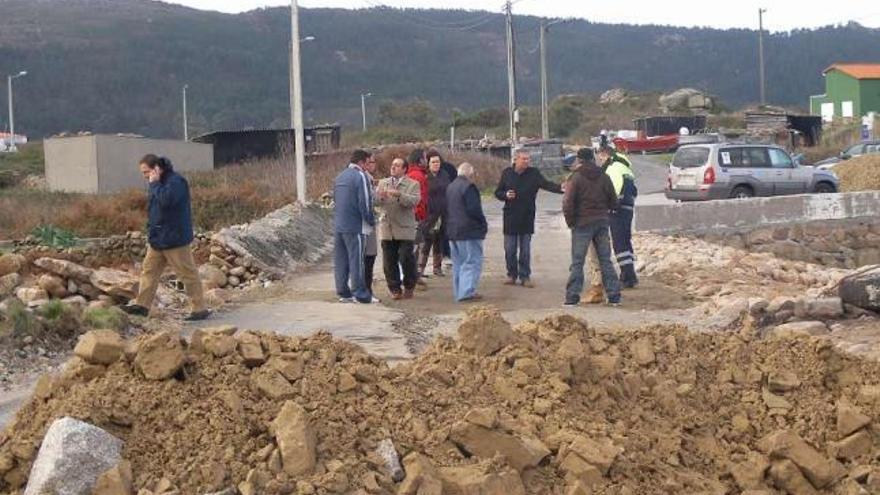 Álvarez-Campana (izquierda) habla por teléfono en la vía dañada junto a representantes del Concello. / m. c. s.