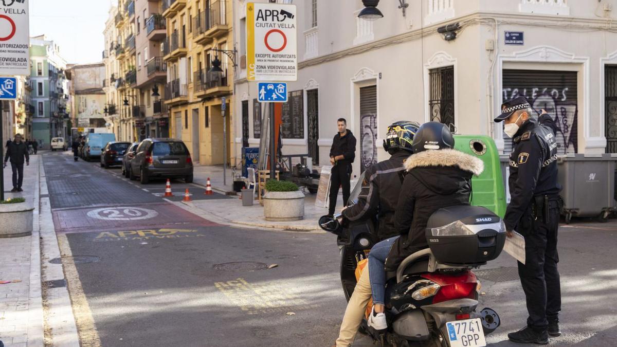 Un agente avisa a una pareja en moto, que va a acceder a la APR donde pueden ser multada. | GERMÁN CABALLERO