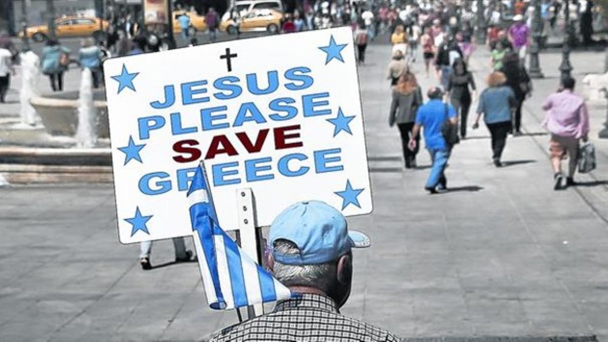 Un hombre pide a Jesús que 'salve' a Grecia,  el lunes en Atenas.