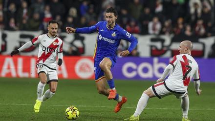 MADRID, 02/01/2026.- El defensa del Getafe Juan Antonio Iglesias (c) se escapa de Isi Palazón (d), del Rayo, durante el encuentro de la jornada 18 de LaLiga que Rayo Vallecano y Getafe CF disputan este viernes en el estadio de Vallecas. EFE/Kiko Huesca