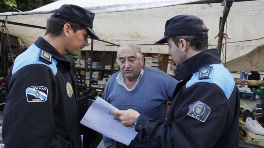 Agentes de la Policía Local entregando folletos informativos en el mercadillo de ayer.  // Bernabé/Gutier