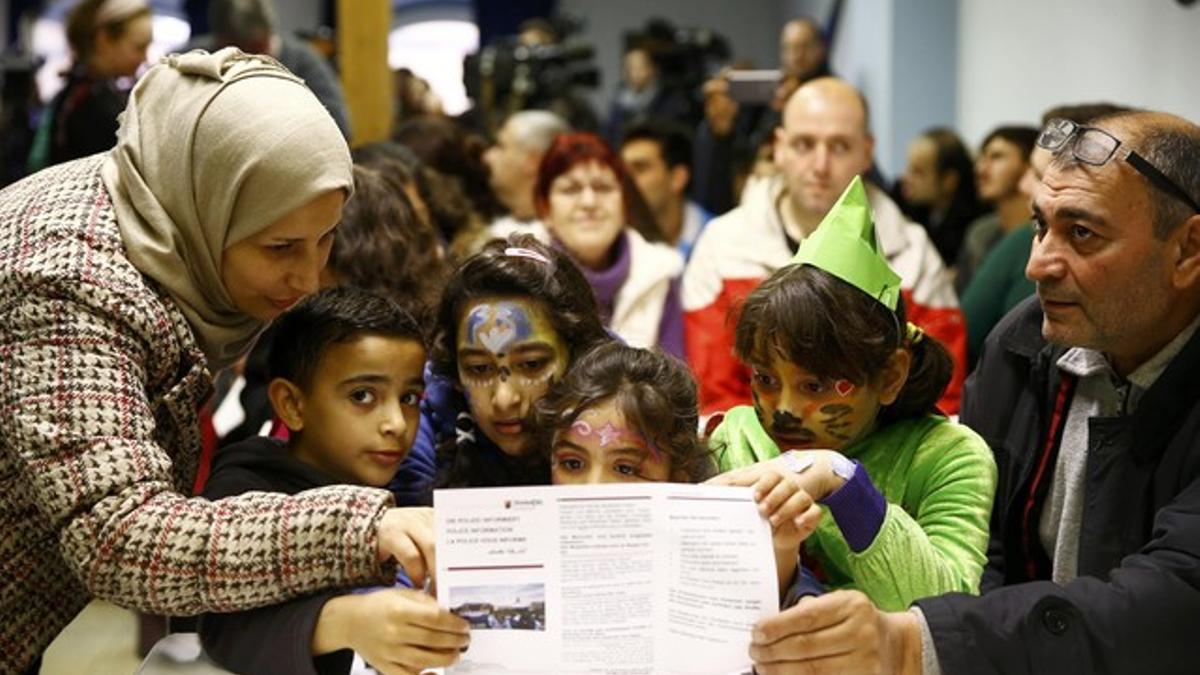 Syrian family read information leaflets on social etiquette ahead of the carnival season at refugee camp in Mainz