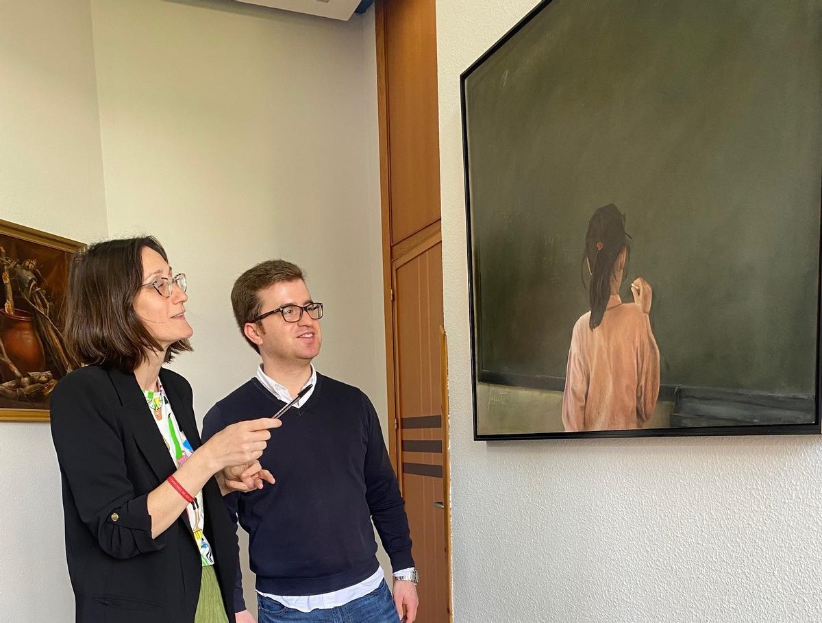 Los concejales Cintia Ordóñez y Arturo Fernández, contemplan una de las obras participantes en una edición anterior del certamen de pintural Nicanor Piñole de San Martín de Rey Aurelio