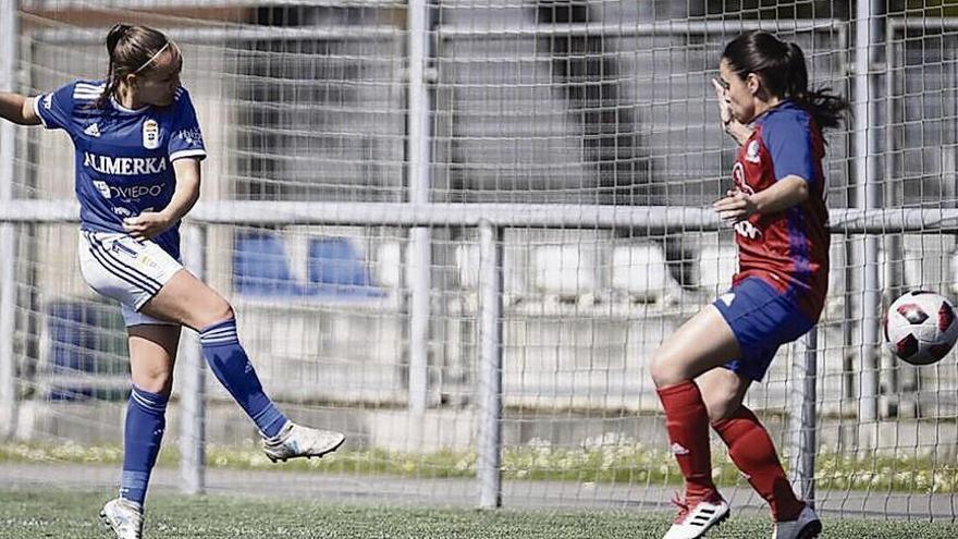 Laura, del Oviedo Femenino, anotando un gol frente al Gijón Femenino, delante de una defensa gijonesa.
