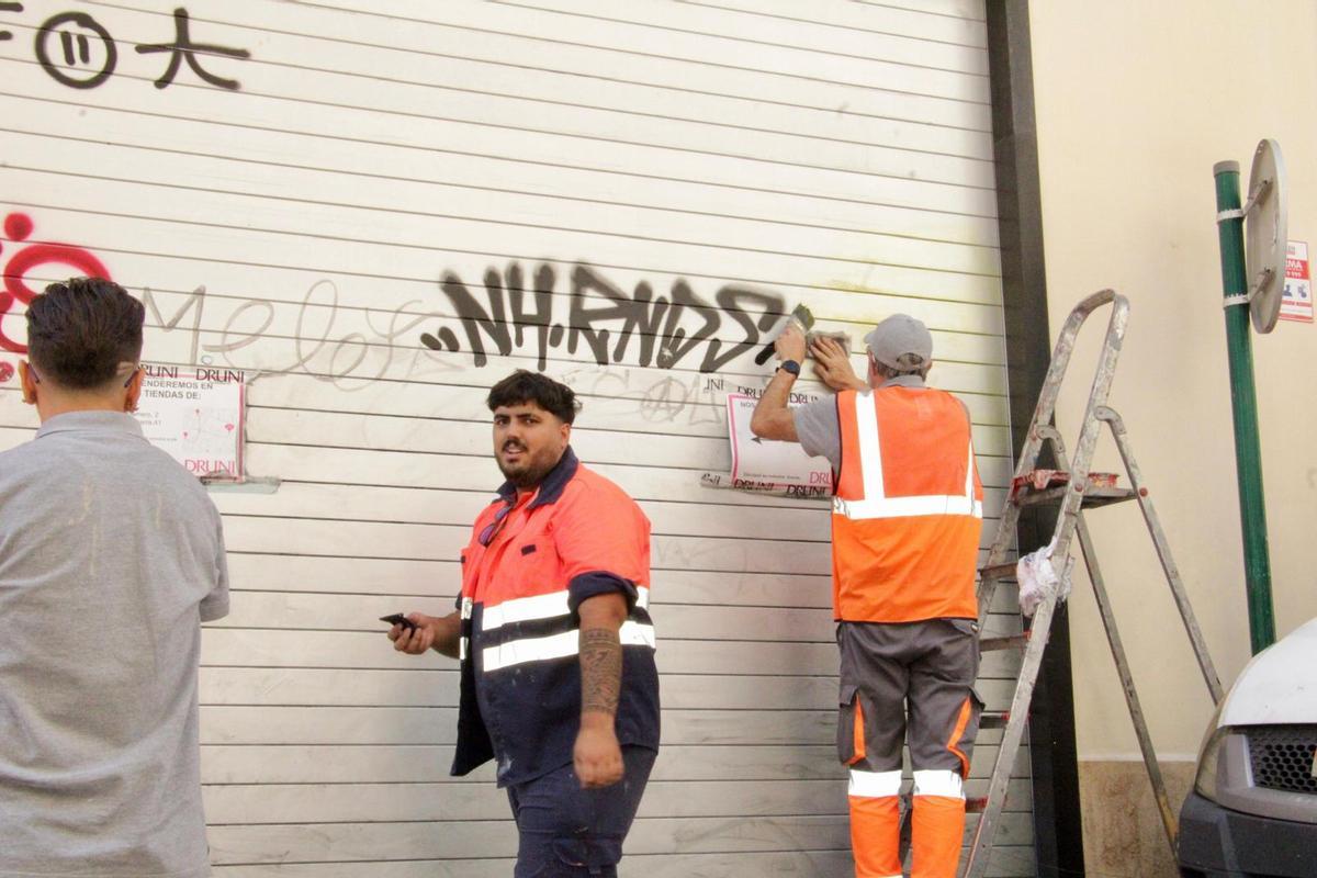 Un momento del borrado de pintadas, en la calle Colón.