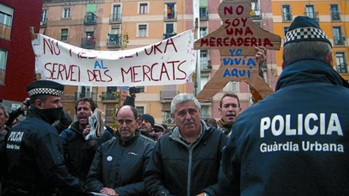 Empleados de TMB y vecinos del Raval protestan, ayer, durante la inauguración de la plaza de Salvador Seguí.