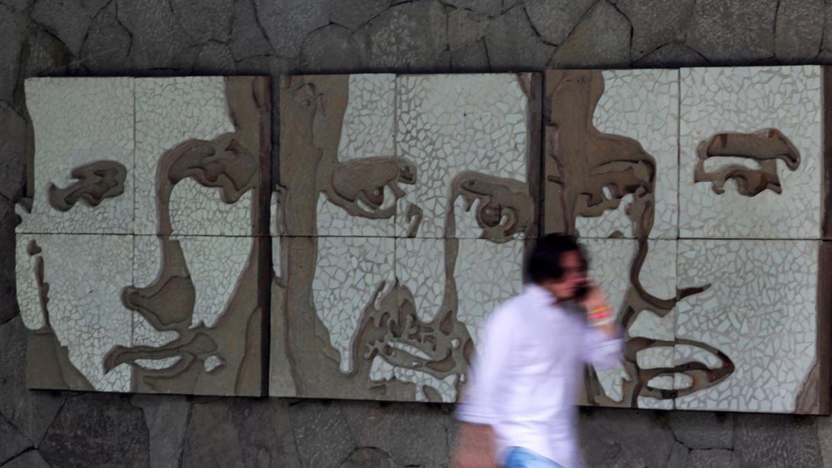 Un hombre pasa frente a un muro con los retratos de tres de los seis jesuitas asesinados en El Salvador en 1989, este miércoles.