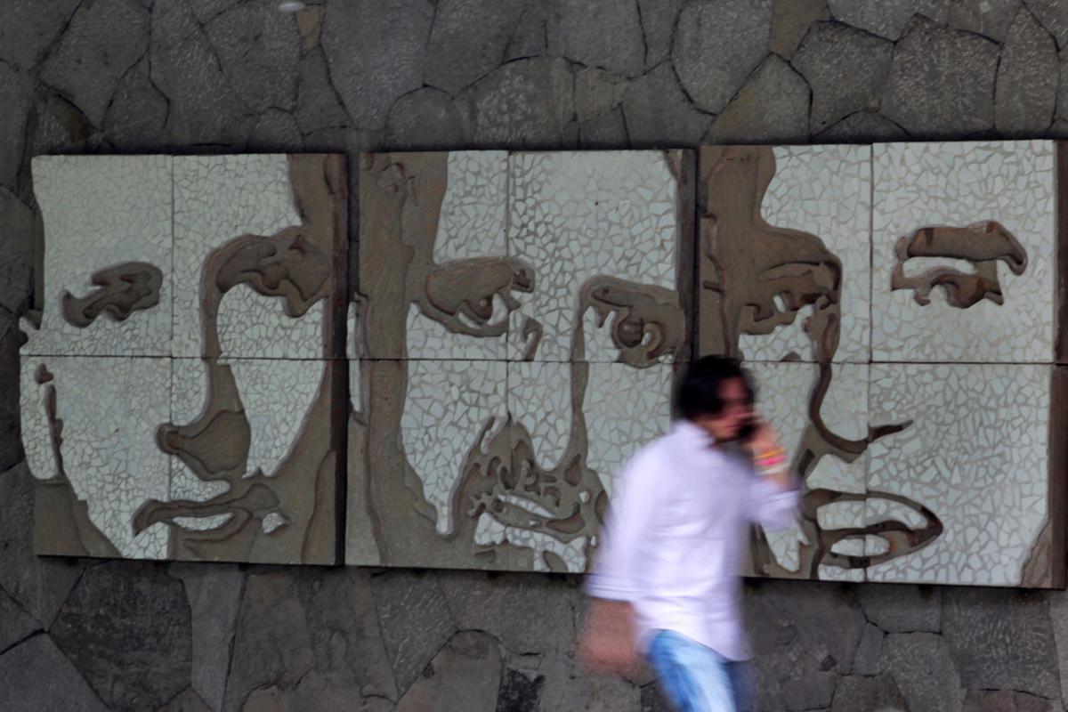 A man walks past portraits of three of the six murdered Jesuit priests, after El Salvador’s Supreme Court denied an extradition request from Spain for a former military colonel facing charges related to the 1989 murder of the priests, in San Salvador, El Salvador, August 17, 2016. REUTERS/Jose Cabezas   EDITORIAL USE ONLY. NO RESALES. NO ARCHIVE.