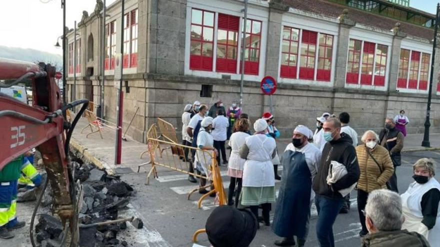 Un grupo de vendedores insta a los operarios a paralizar la obra y reabrir el tramo de calle, ayer.  | / FDV