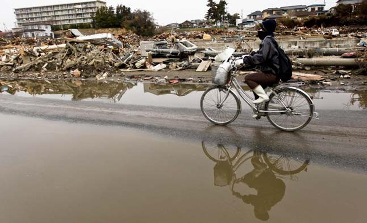 Una dona travessa en bicicleta la devastada ciutat d’Ishinomaki, a la prefectura de Miyagi (Japó). El nombre de morts pel terratrèmol i el tsunami de l’11 de març al nord-est del Japó s’ha elevat avui a 12.596, al mateix temps que 14.747 persones més segueixen desaparegudes, segons l’últim recompte policial. A més, en més de 2.000 refugis temporals continuen evacuades prop de 160.000 persones provinents de les províncies nord-orientals de Miyagi, Iwate i Fukushima, les més devastades per la catàstrofe.