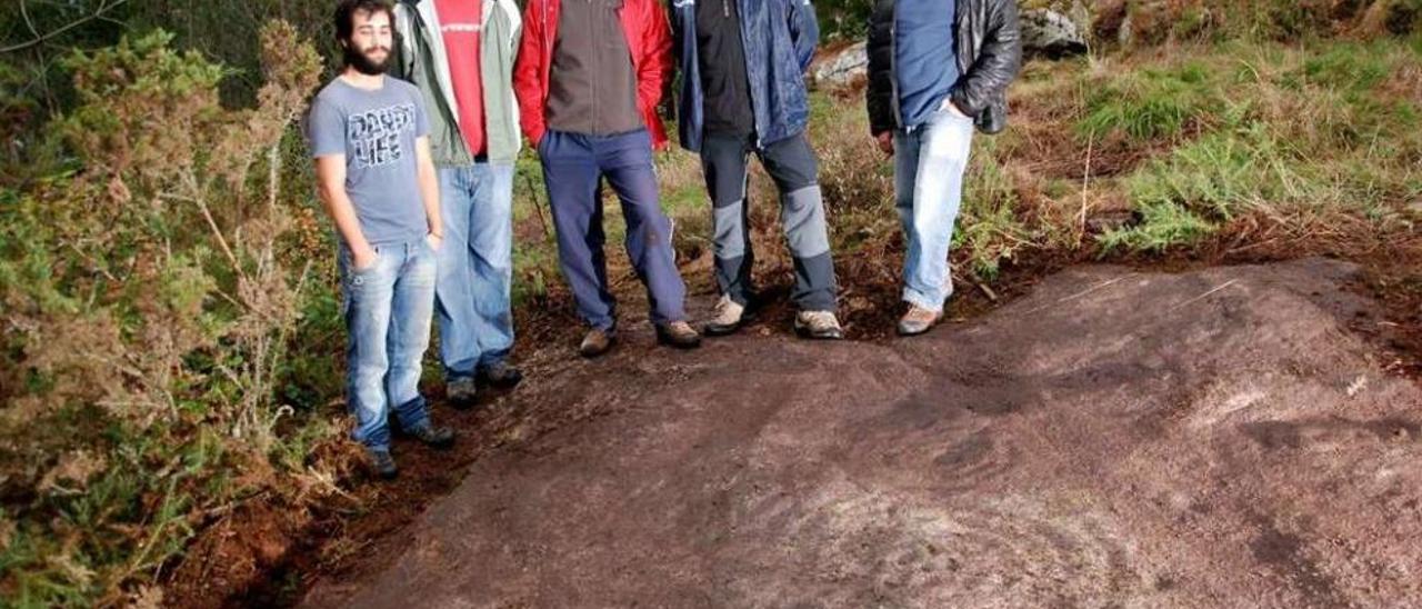 Miembros de Capitán Gosende junto al petroglifo Laxa da Romaxe II.