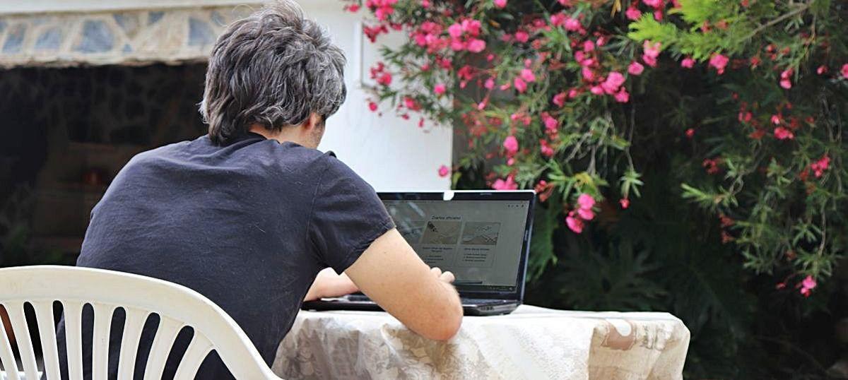Un vecino de una partida alicantina, en el campo, trabajando con el ordenador en su segunda residencia.