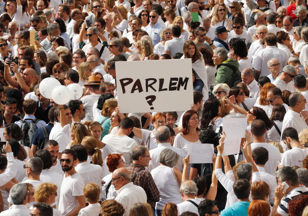 A woman holds up a sign that redads  shall we talk   in Catalan during a demonstration in a square in Barcelona  Spain  October 7  2017 REUTERS Eric Gaillard