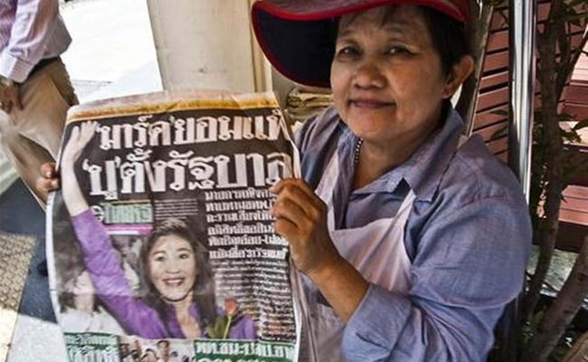 Una dona tailandesa llegeix un diari amb la notícia de la clara victòria del partit Puea Thai sobre el partit Demòcrata del primer ministre, Abhisit Vejjajiva, a les eleccions generals d’ahir.
