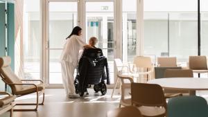 Una sanitaria y un paciente en el centro diurno de ELA