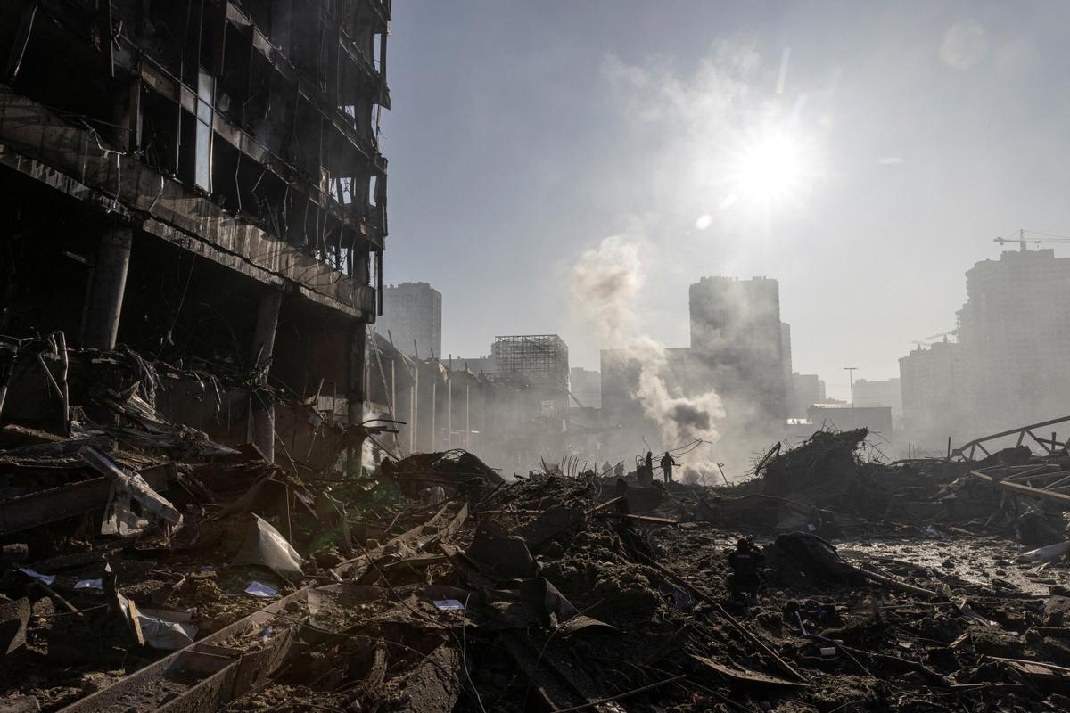 Los bomberos trabajan en el lugar de un atentado con bomba en un centro comercial mientras continúa la invasión rusa de Ucrania, en Kiev.