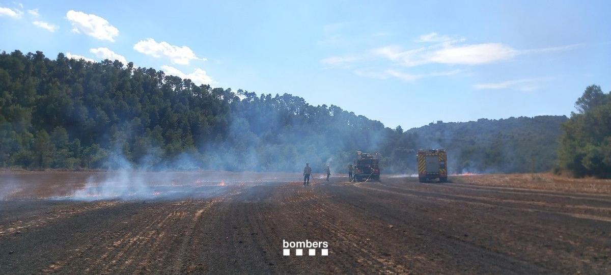 Dos camions de Bombers treballant amb el sistema d'extinció en marxa aquest migdia a Clariana de Cardener