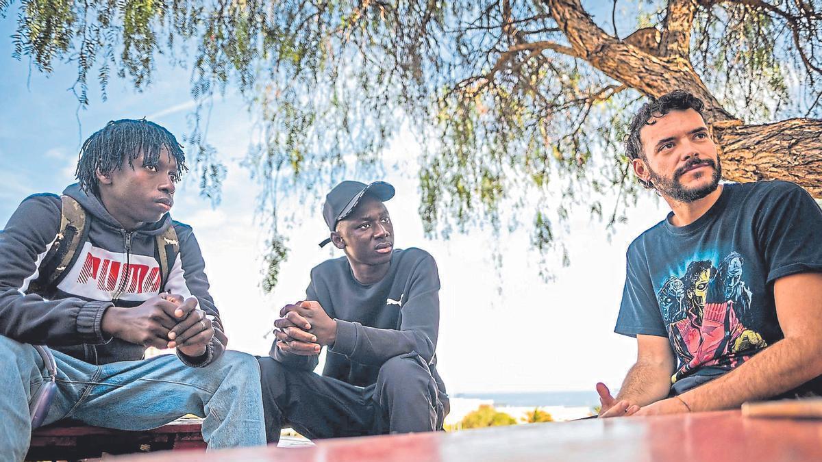 De izquierda a derecha: los migrantes Thiemoko y Yaya y el investigador Lorenzo Caglioni conversan en Añaza.