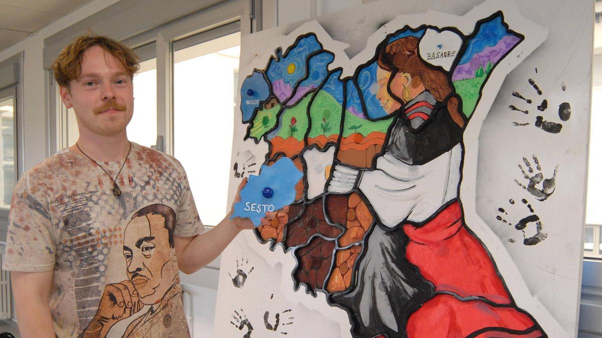 August André posa junto al mural-puzzle creado por él y sus alumnos del CEIP de Agolada.