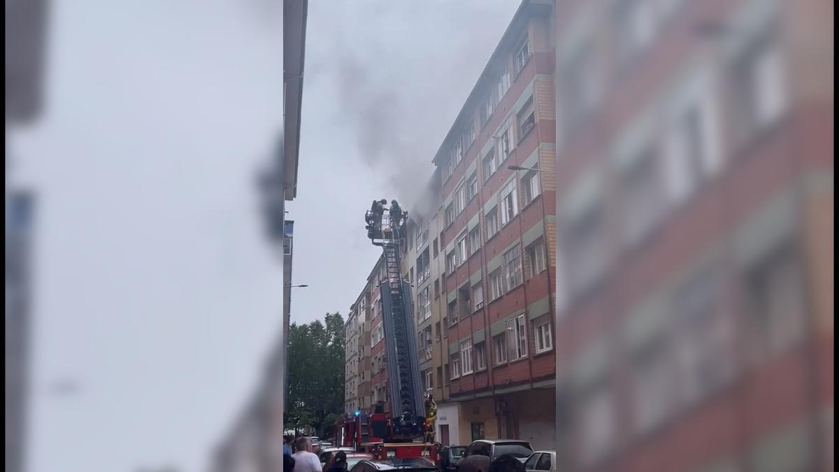 Intervención de bomberos sofocando un incendio en un piso de Gijón
