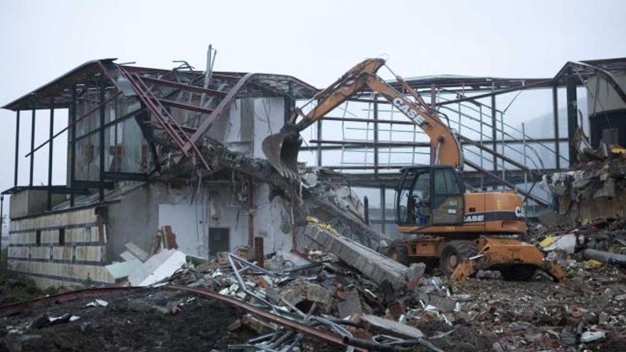 Una pala excavadora, ayer, derribando la estructura del centro ambiental de El Entrego.