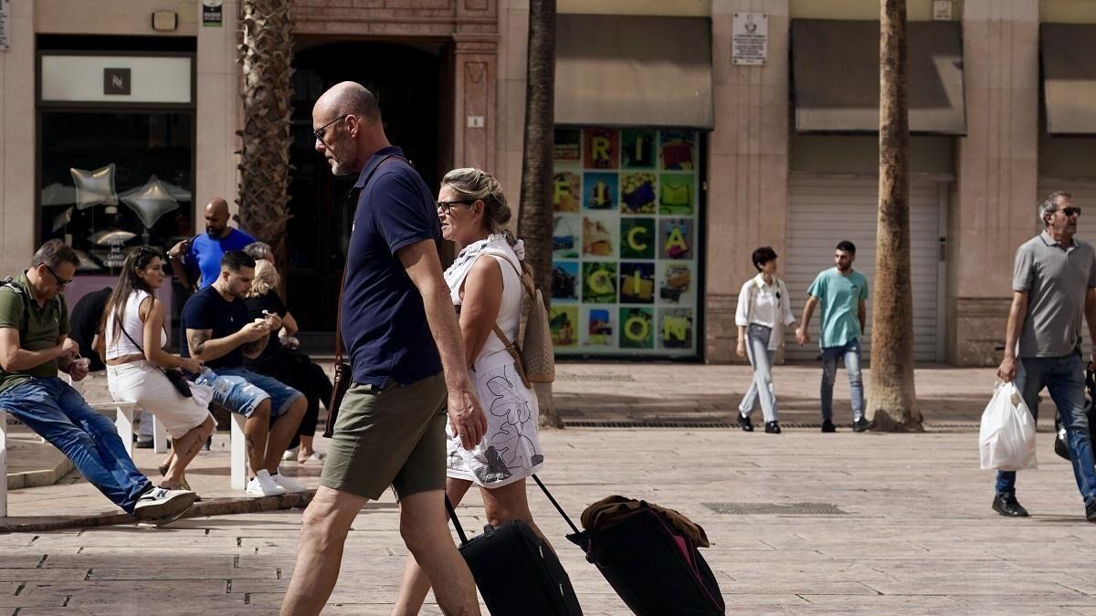 Turistas con sus maletas en el Centro de Málaga