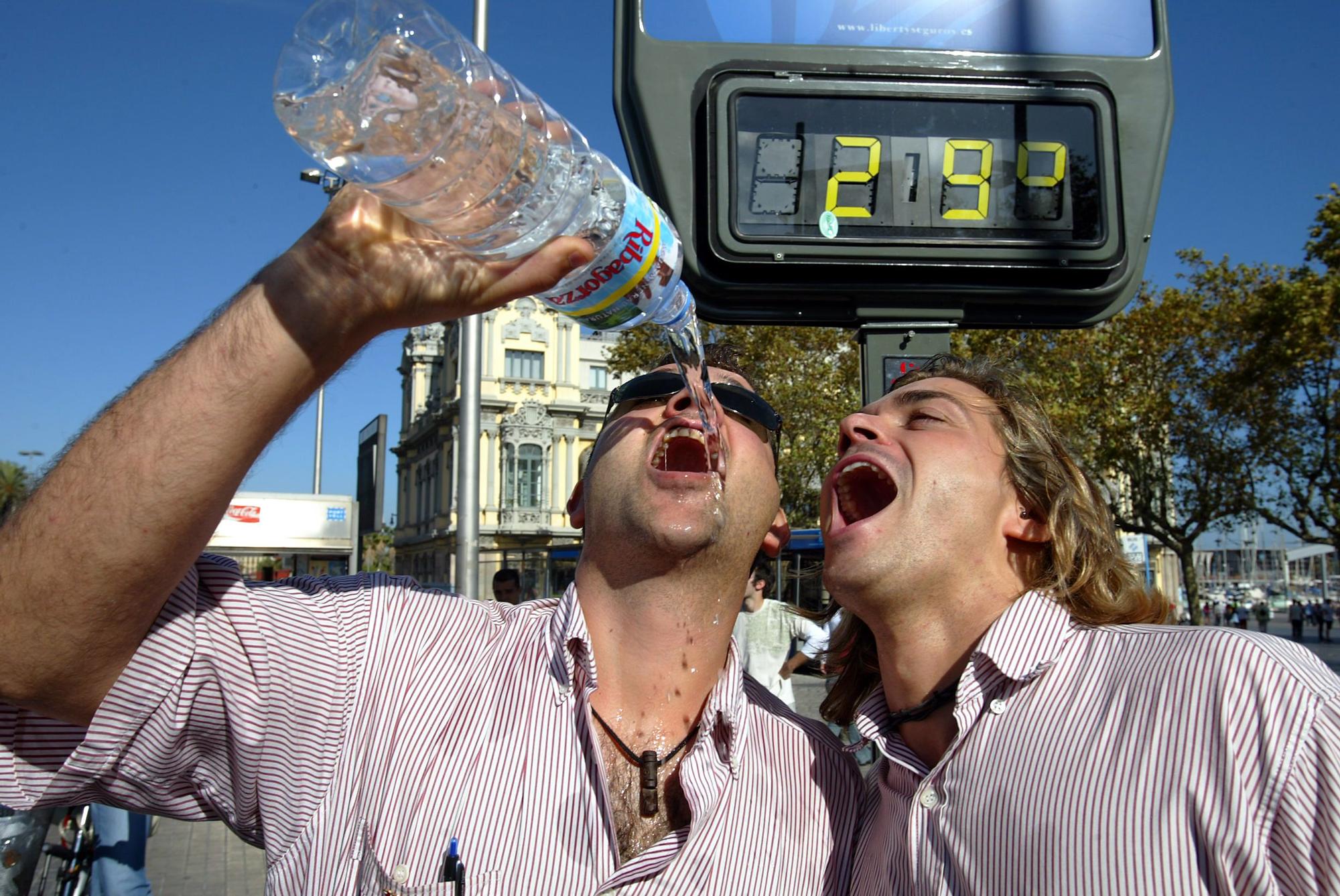 Dos jóvenes beben agua en un día caluroso en Barcelona, en una imagen de archivo