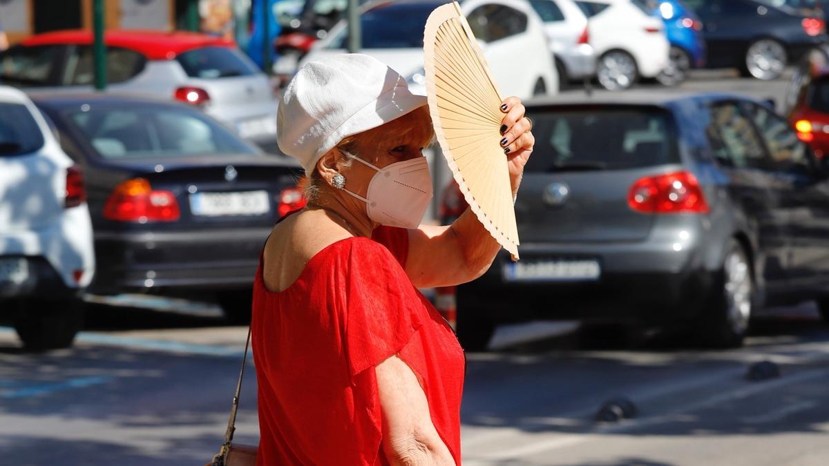 Una mujer se protege del sol con un abanico en Murcia.