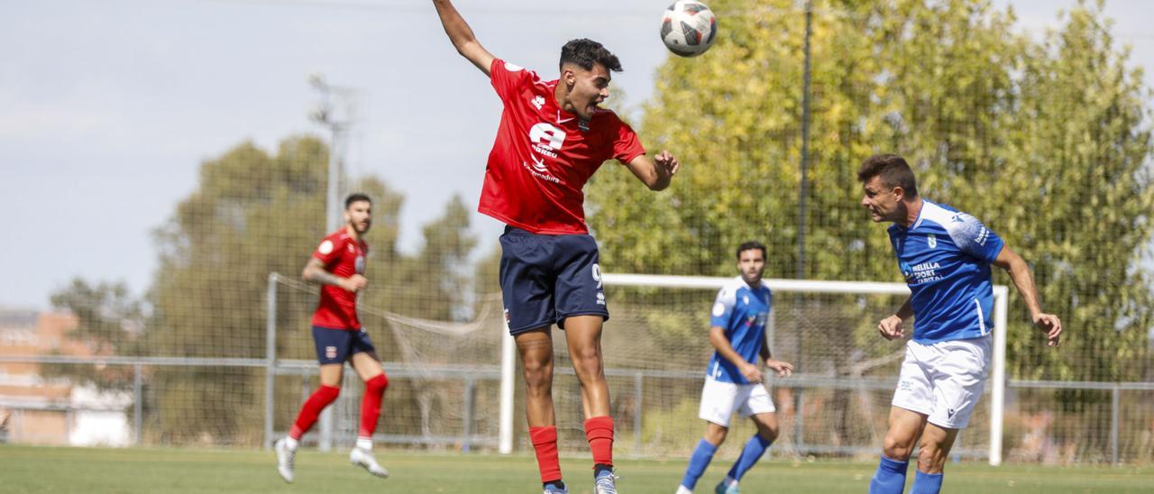 Rayco, derecha, golpea de cabeza durante el partido ante el Melilla.