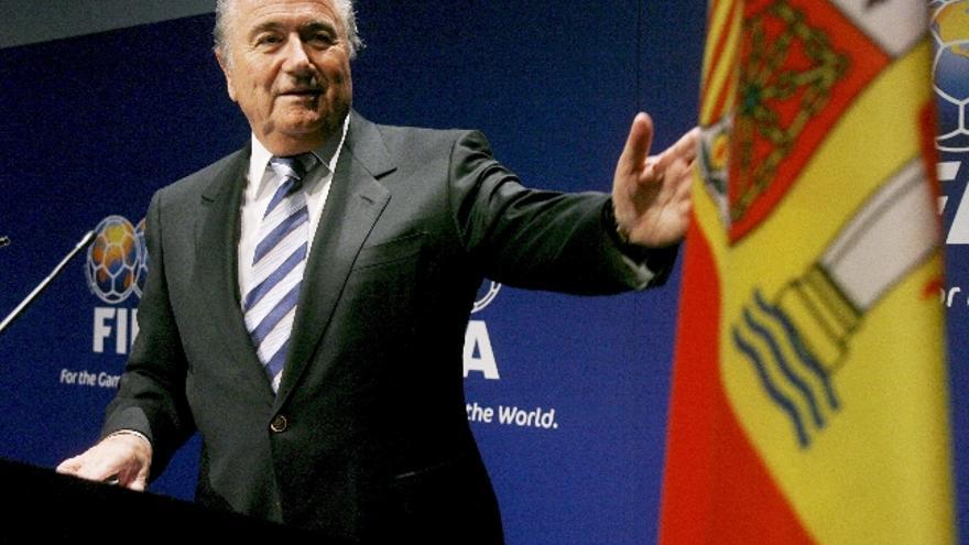 El presidente de la Federación Internacional de Fútbol Asociado (FIFA), Joseph Blatter (i), observa una bandera de España durante su intervención ante unos cuarenta presidentes de clubes de primera y segunda división de la liga española.