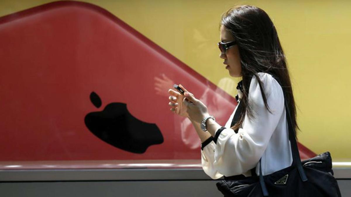 Una mujer japonesa consulta su teléfono móvil, en una calle de Tokio.