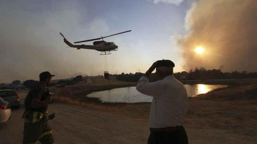 Un helicóptero carga agua en una charca para apagar el incendio de Villardiegua de la Ribera en agosto de 2013.