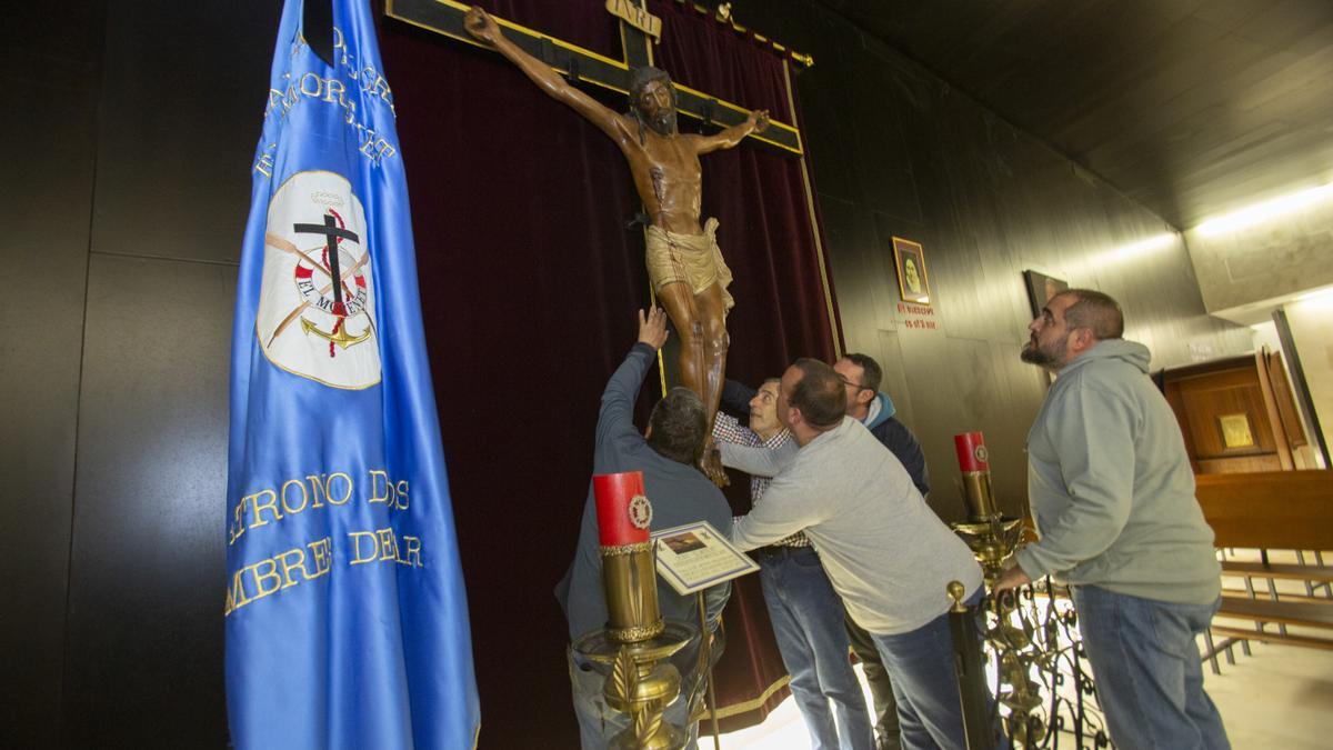 Varios hermanos de la cofradía colocan la imagen del Cristo de El Morenet.