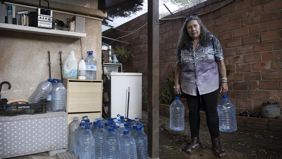 Àngela Balcells en su casa con garrafas de agua en Molins de Rei