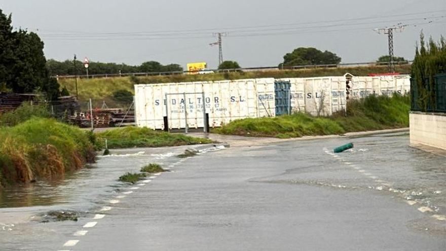 L’aigua del barranc de la Foia obliga a tallar un camí rural al costat del polígon de Sollana
