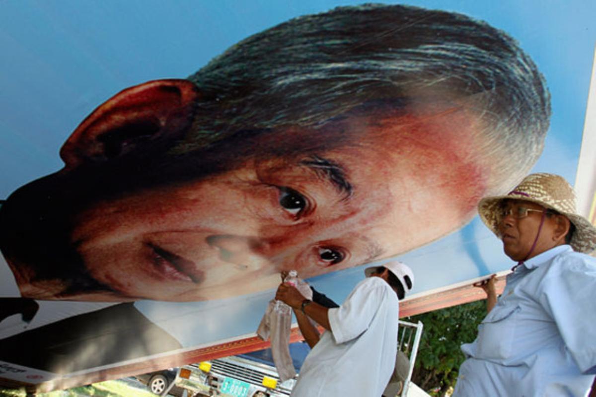 Un treballador neteja un retrat de l’exrei Norodom Sihanouk de Cambodja davant el Palau Reial de Phnom Penh.