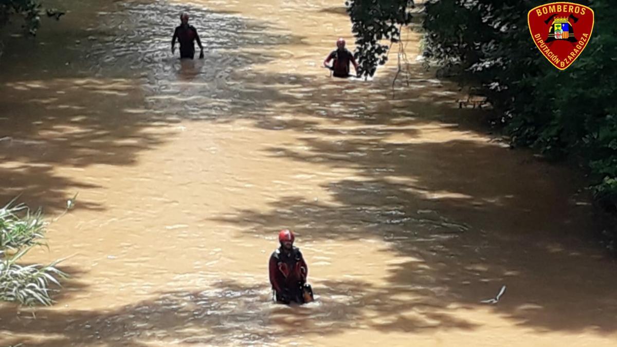 Varios bomberos vadean el río Jalón en busca de la desaparecida.