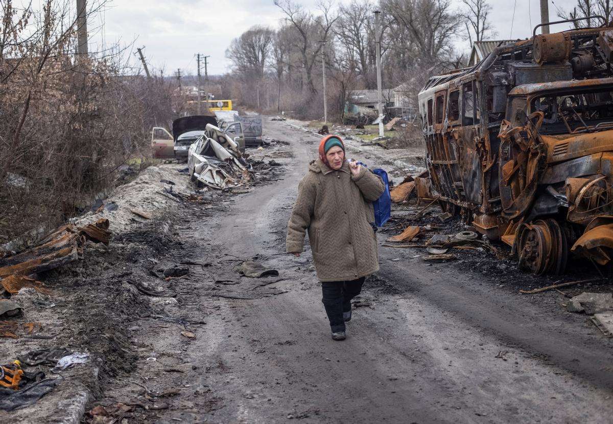 Una mujer, junto a los restos de vehículos destrozados por un bombardeo Torske, Donetsk (Ucrania).