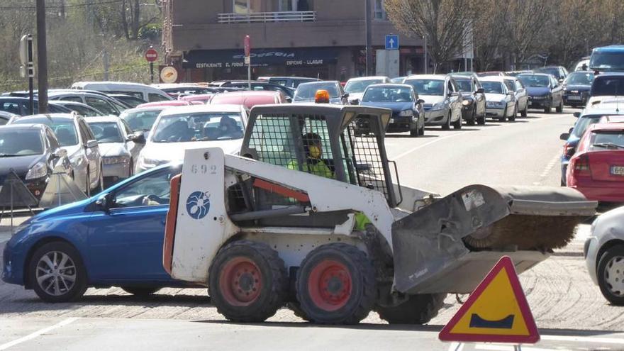 Obras en la calle Alcalde Parrondo, con una larga hilera de vehículos parados.