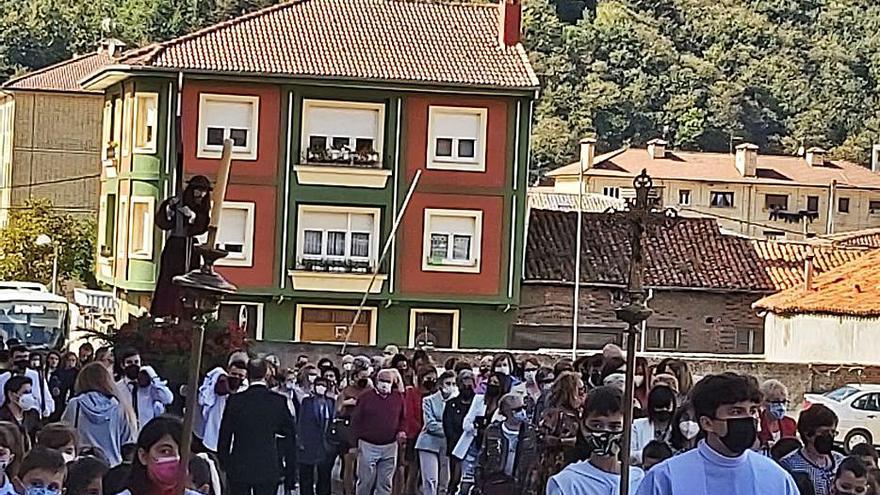 Sobre estas líneas, el concierto de la Banda de música de Laviana. Arriba, la procesión en su recorrido por la calle Luis Alonso. | E. P.